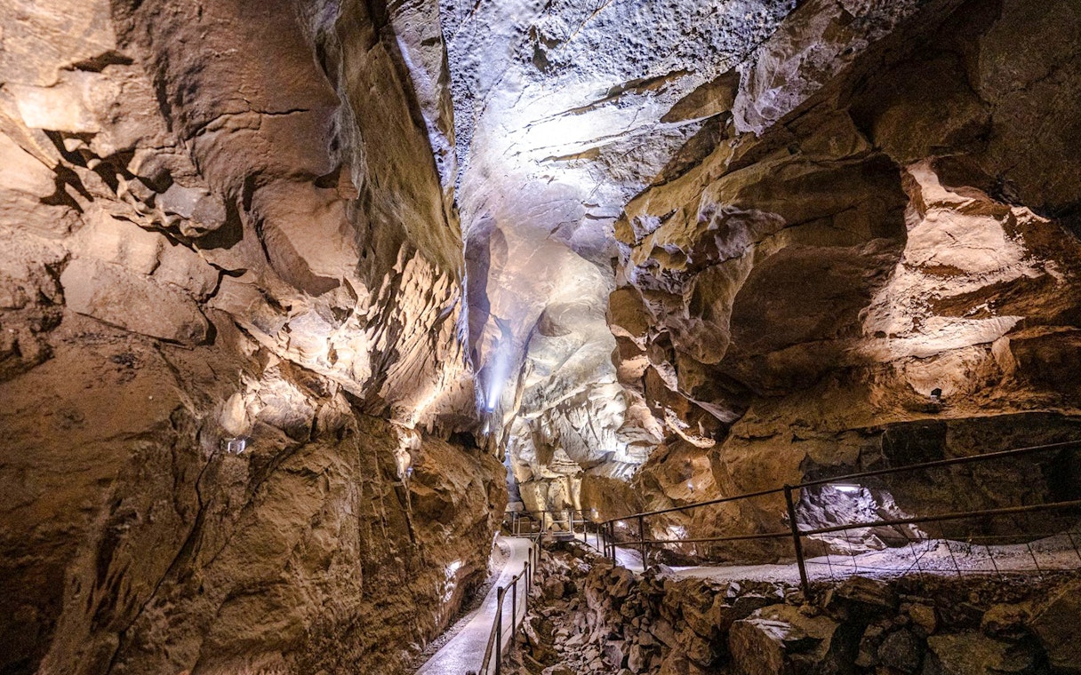 Aillwee Caves passageway with illuminated rock formations in County Clare, Ireland.