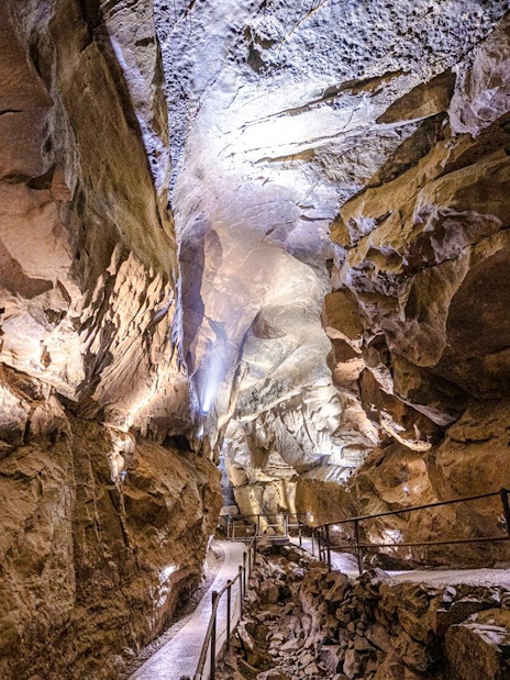 Aillwee Caves passageway with illuminated rock formations in County Clare, Ireland.