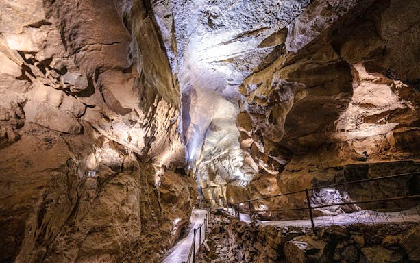 Aillwee Caves passageway with illuminated rock formations in County Clare, Ireland.