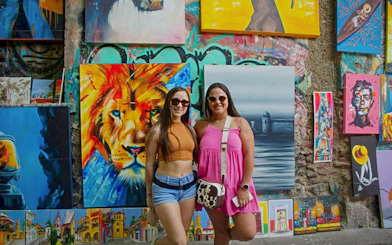 Travelers in front of vibrant street art in Getsemaní, Cartagena.