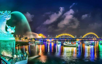 Dragon Bridge and Han River at night with colorful lights, Da Nang, Vietnam.