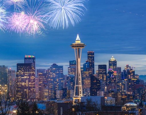 Seattle Space Needle with fireworks in the night sky.