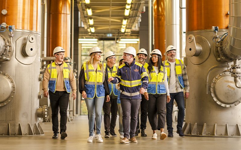 Guests touring Midleton Distillery with guide, wearing safety gear.