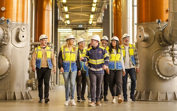 Guests touring Midleton Distillery with guide, wearing safety gear.