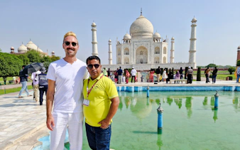 Tourists at the Taj Mahal with reflecting pool, part of the Agra day tour from Delhi.