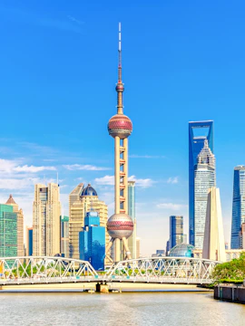 Oriental Pearl Tower in Shanghai skyline with modern skyscrapers and river.