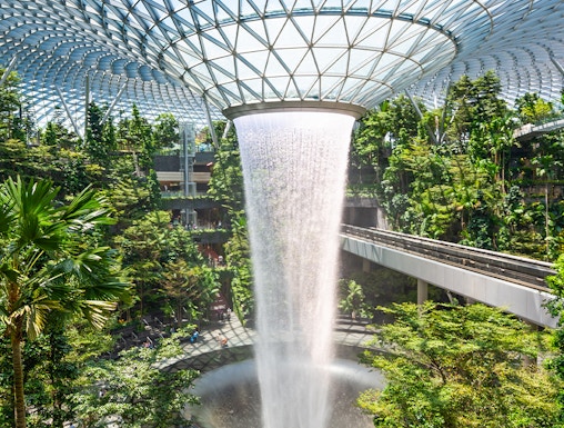 Jewel Changi indoor waterfall surrounded by lush greenery in Singapore.