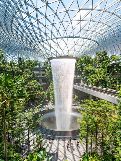 Jewel Changi indoor waterfall surrounded by lush greenery in Singapore.