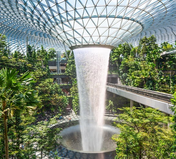 Jewel Changi indoor waterfall surrounded by lush greenery in Singapore.