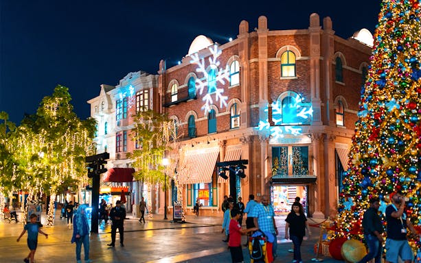 Festive decorations and visitors at MOTIONGATE™ Dubai during nighttime.
