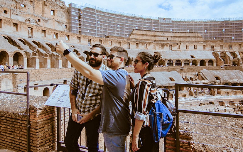 Tourists taking a selfie inside the Colosseum during an express guided tour.