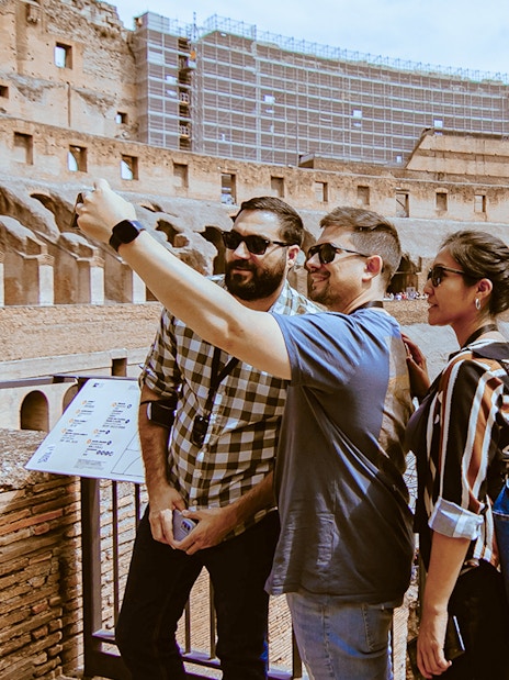 Tourists taking a selfie inside the Colosseum during an express guided tour.