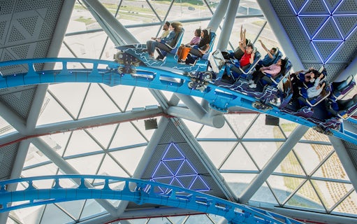 Riders on The Storm Coaster in Dubai inside a futuristic glass structure.