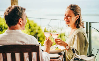 Couple enjoying lunch with wine at Coloured Earth, Chamarel, Mauritius.