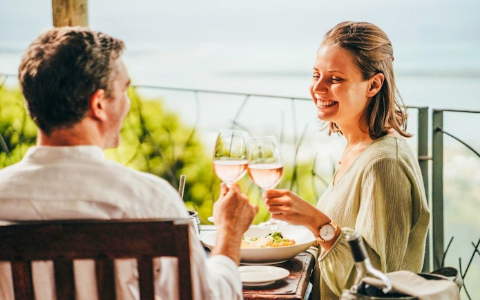 Couple enjoying lunch with wine at Coloured Earth, Chamarel, Mauritius.