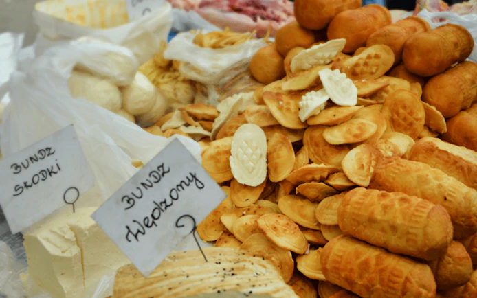 Kraków street market with traditional Polish cheeses, including Bundz and Oscypek.