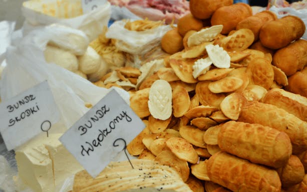 Kraków street market with traditional Polish cheeses, including Bundz and Oscypek.