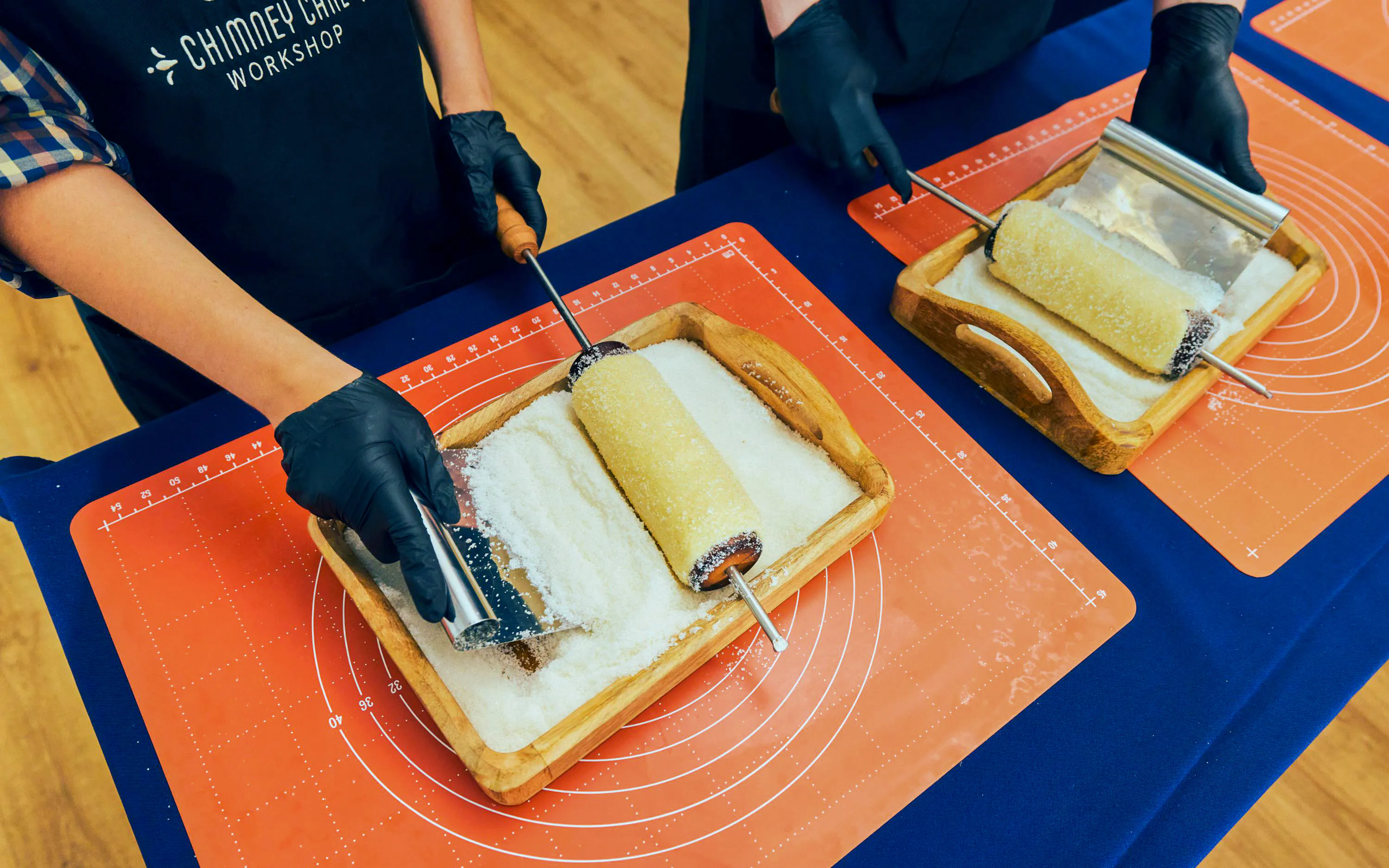 Participants preparing chimney cakes at a workshop in Budapest.