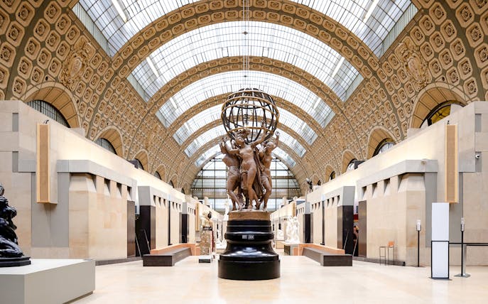 Orsay Museum interior with sculptures and ornate ceiling, Paris, France.