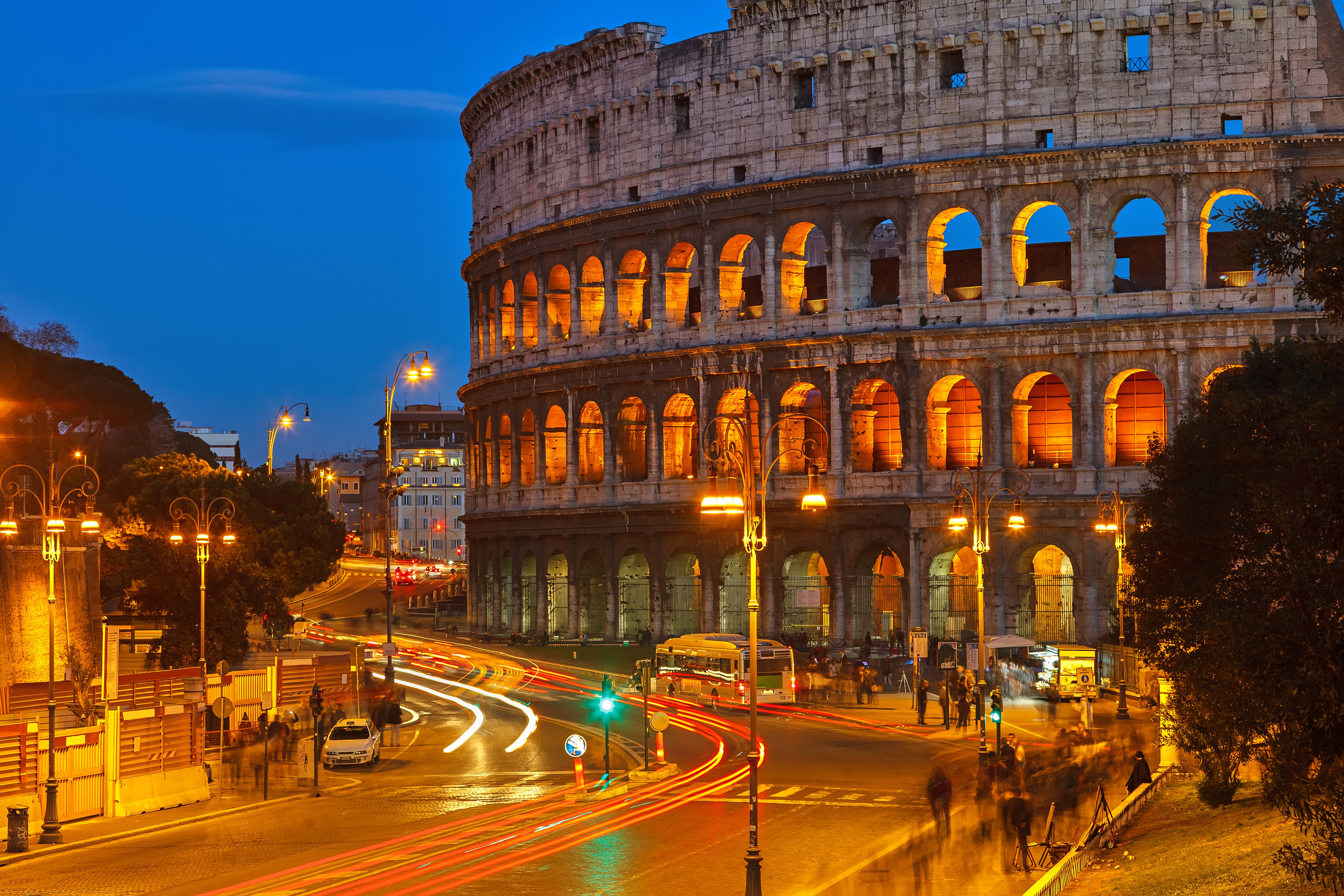 Colosseum illuminated at night in Rome, Italy, showcasing ancient Roman architecture.