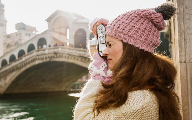 Woman photographing Rialto Bridge during Venice photo walk.