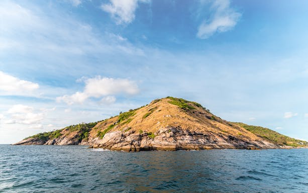 Promthep Cape in Phuket with rocky coastline and clear blue sky.