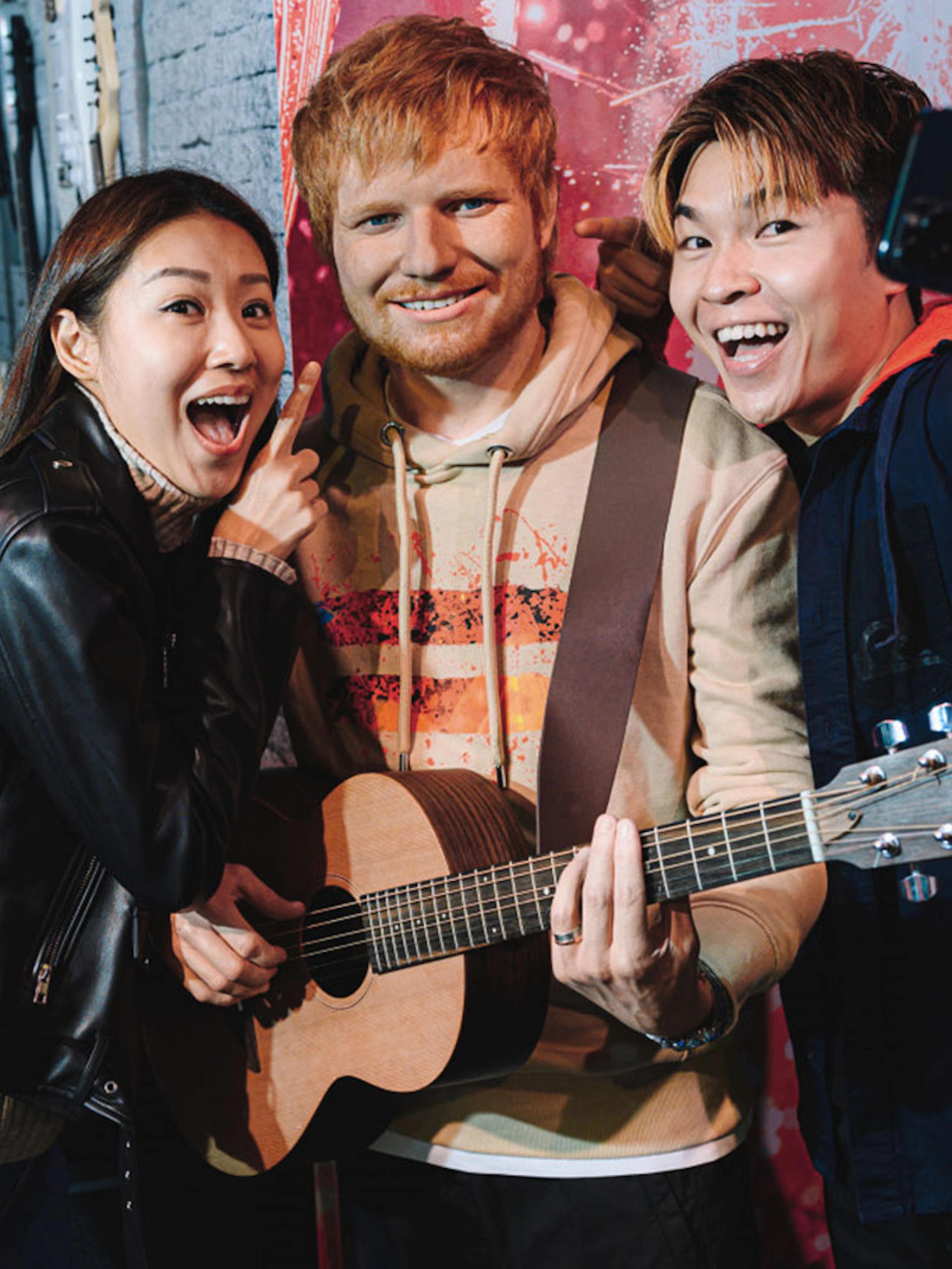 Visitors taking a selfie with a wax figure at Madame Tussauds Hong Kong.