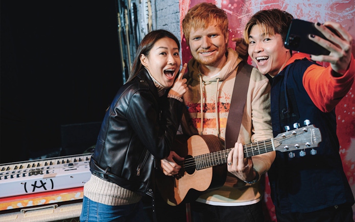 Visitors taking a selfie with a wax figure at Madame Tussauds Hong Kong.