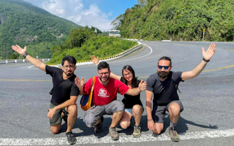 Group of friends posing on Hai Van Pass during Hue to Da Nang private car tour.