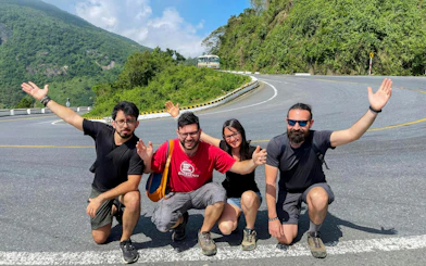 Group of friends posing on Hai Van Pass during Hue to Da Nang private car tour.