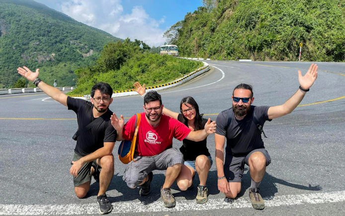 Group of friends posing on Hai Van Pass during Hue to Da Nang private car tour.