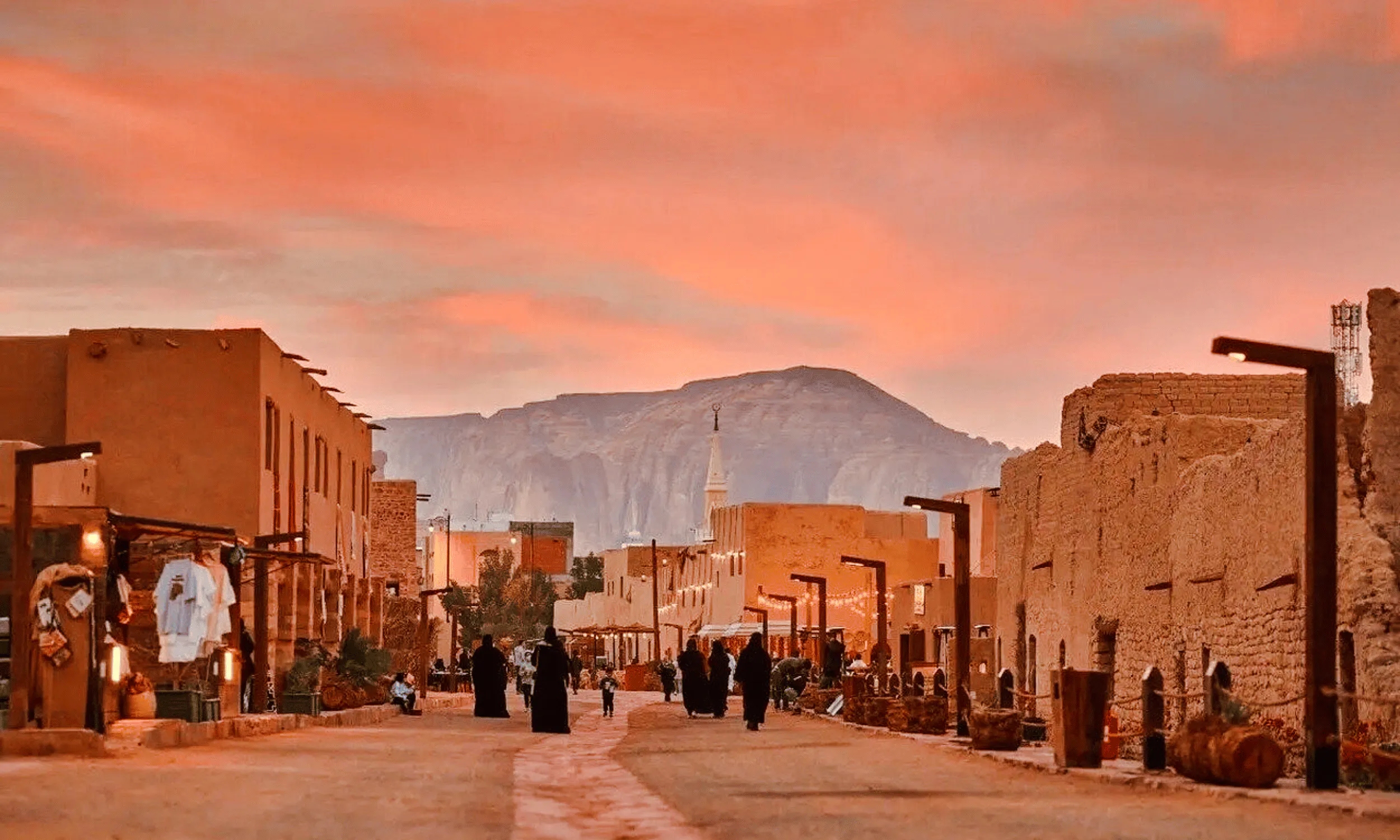 Historic AlUla street at sunset with distant mountain, Medina day trip.