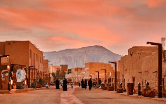 Historic AlUla street at sunset with distant mountain, Medina day trip.