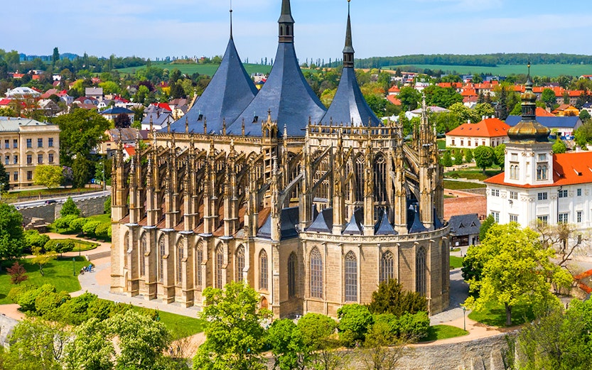 St. Barbara's Church in Kutna Hora with surrounding greenery and town view.