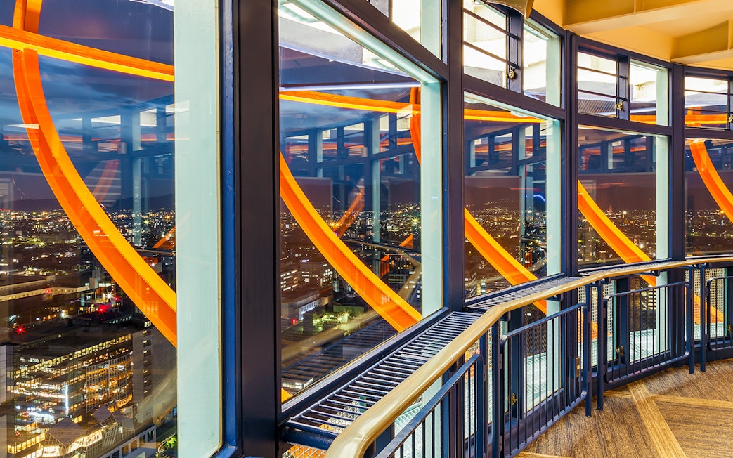 Kyoto Tower observation deck illuminated at night with city view.