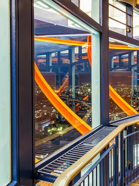 Kyoto Tower observation deck illuminated at night with city view.
