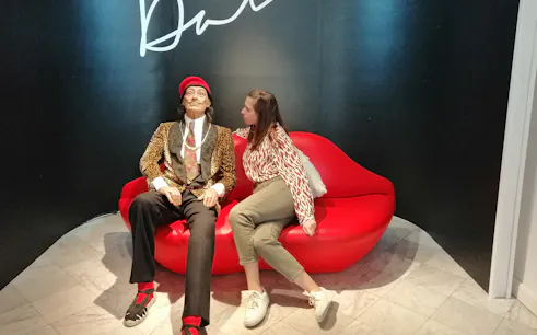 Person sitting next to a wax figure at Barcelona Wax Museum during VIP tour.