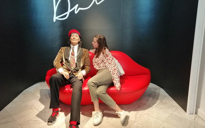 Person sitting next to a wax figure at Barcelona Wax Museum during VIP tour.