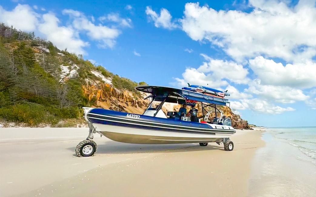 Sealegs boat on K'gari beach, Fraser Island, with coastal cliffs in the background.