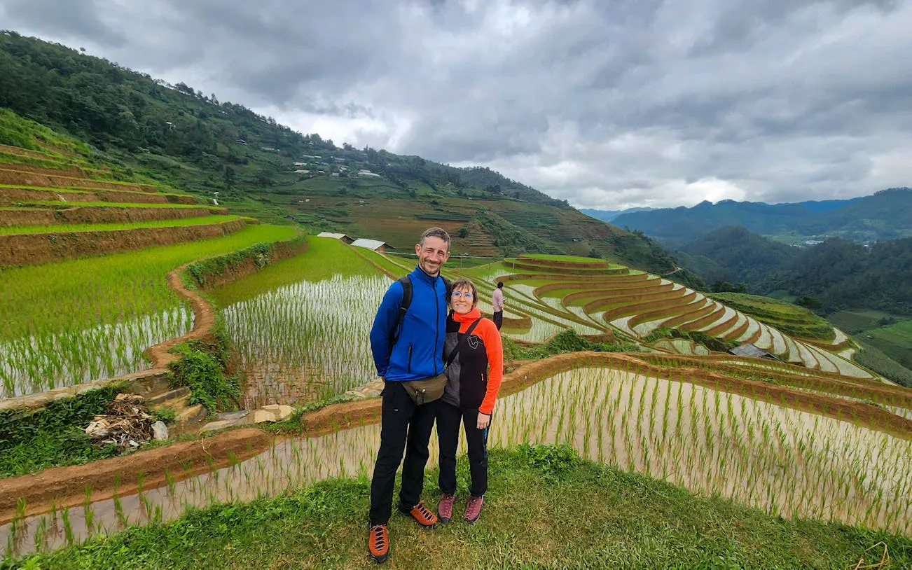 Couple standing by terraced rice fields in Mu Cang Chai during trekking and motorbike tour.