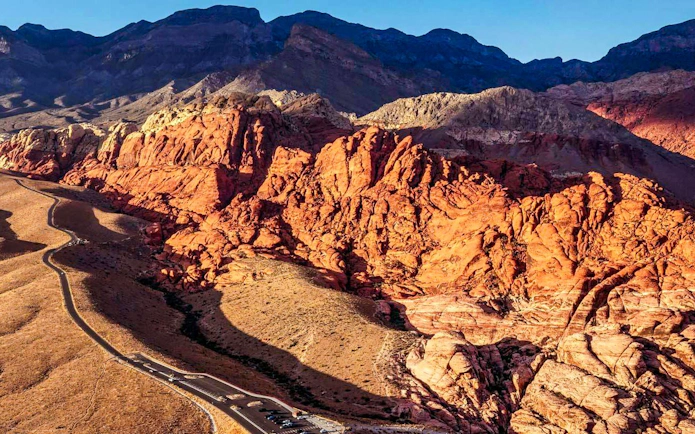 Red Rock Canyon's vibrant cliffs and winding road, view from helicopter tour, Las Vegas.