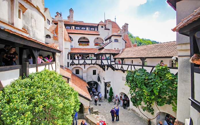 Bran Castle courtyard with stone walls and arched windows, Transylvania, Romania.