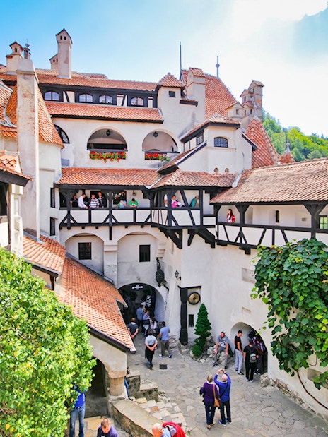 Bran Castle courtyard with stone walls and arched windows, Transylvania, Romania.