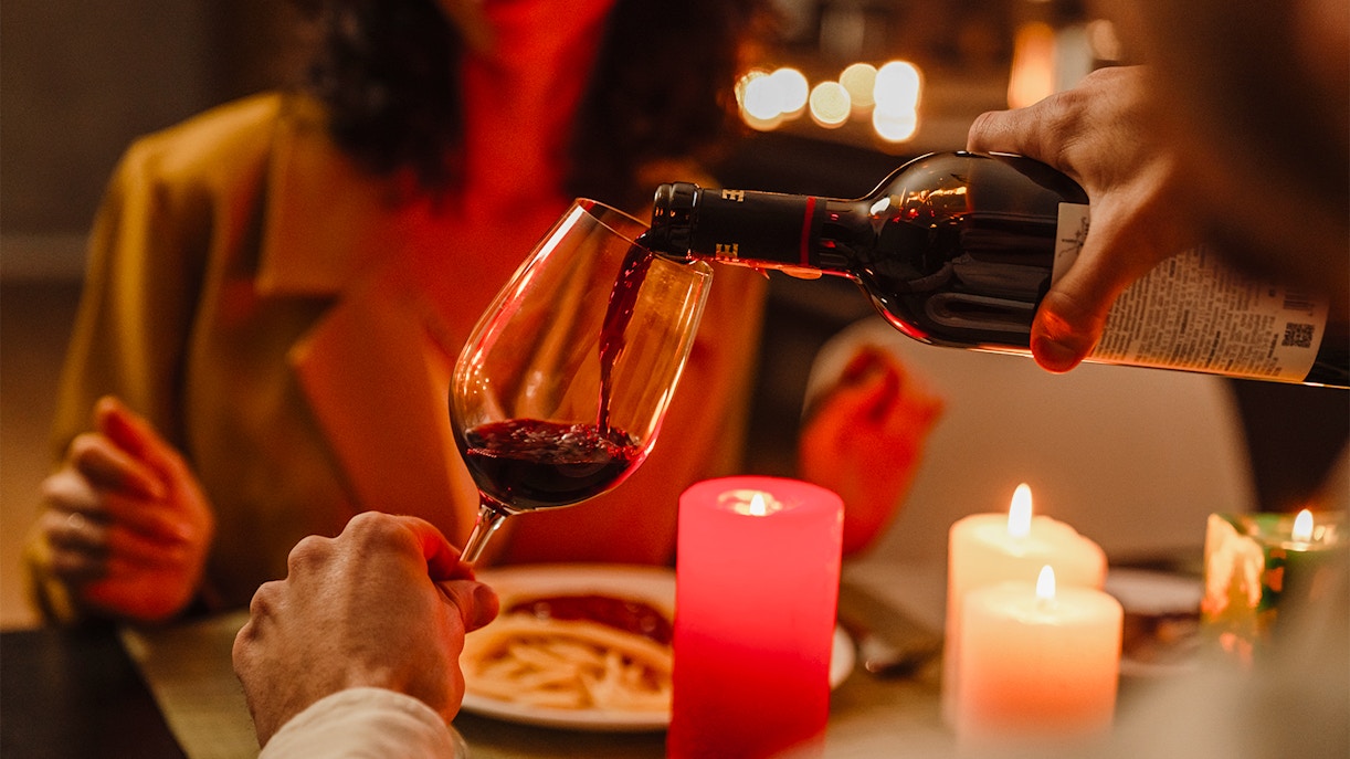 Couple enjoying candlelit dinner with wine in New York.