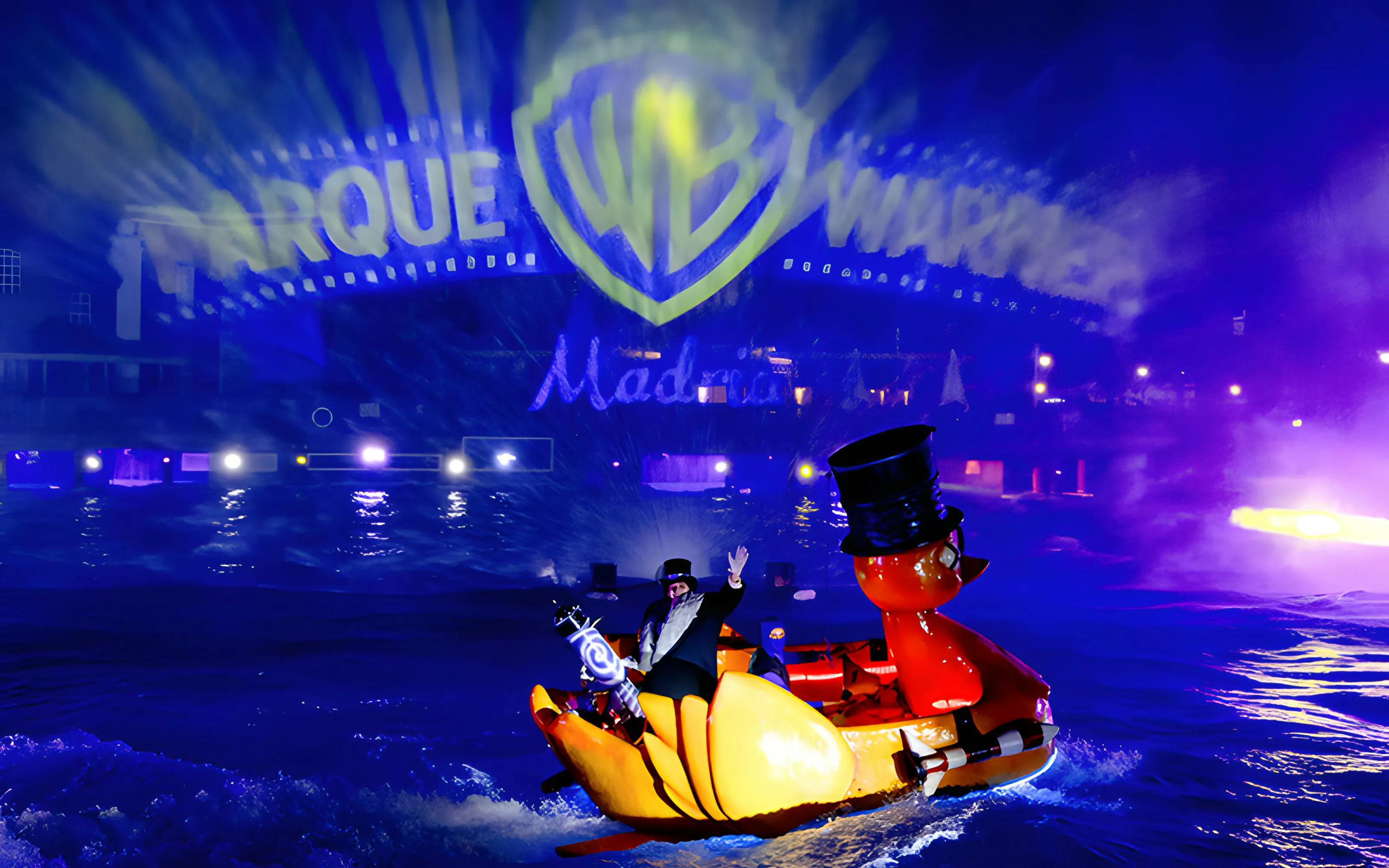 Parque Warner night show with illuminated water display and character boat in Madrid.