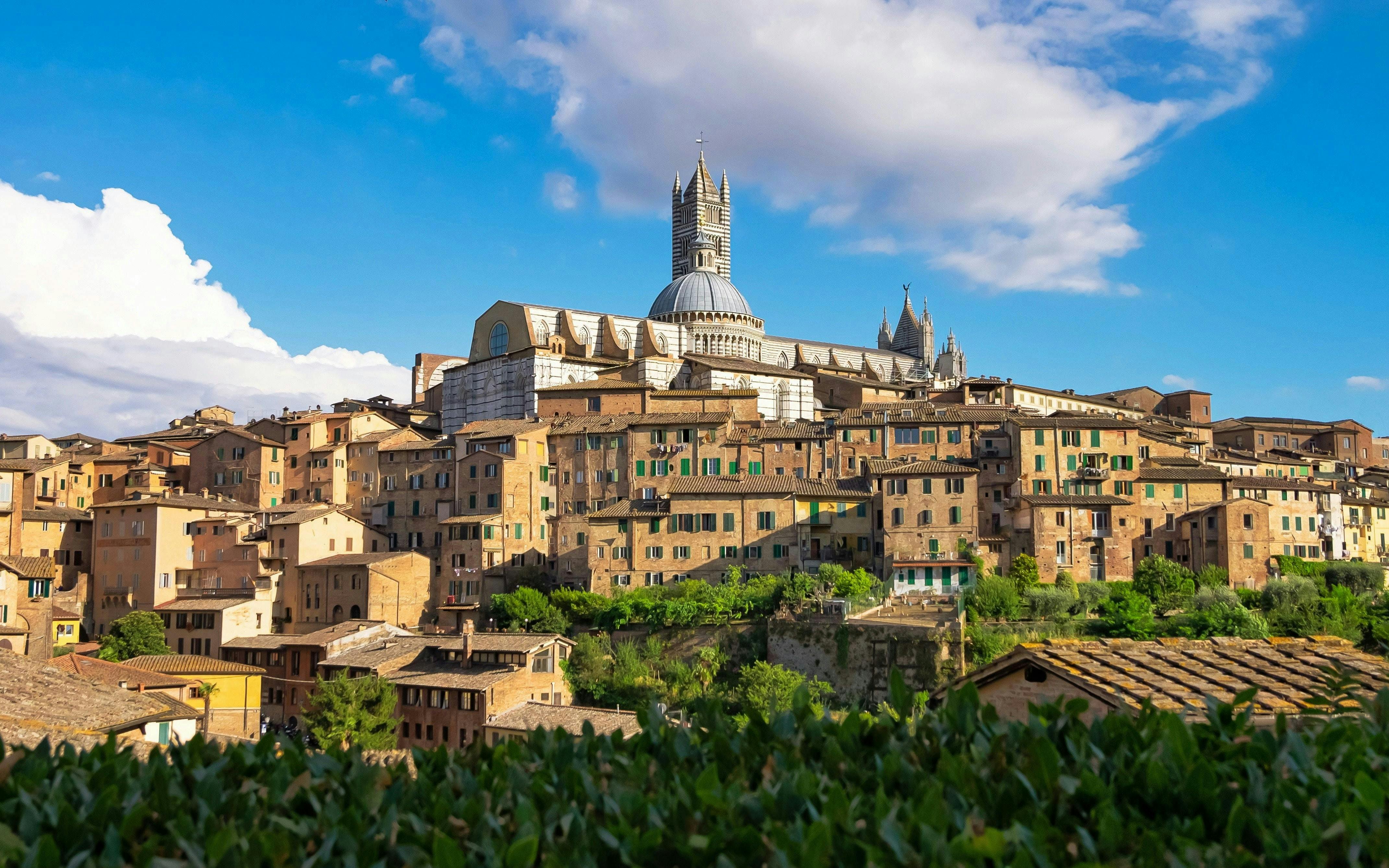 Siena Cathedral rising above the medieval hilltop town of Siena, Tuscany, Italy.