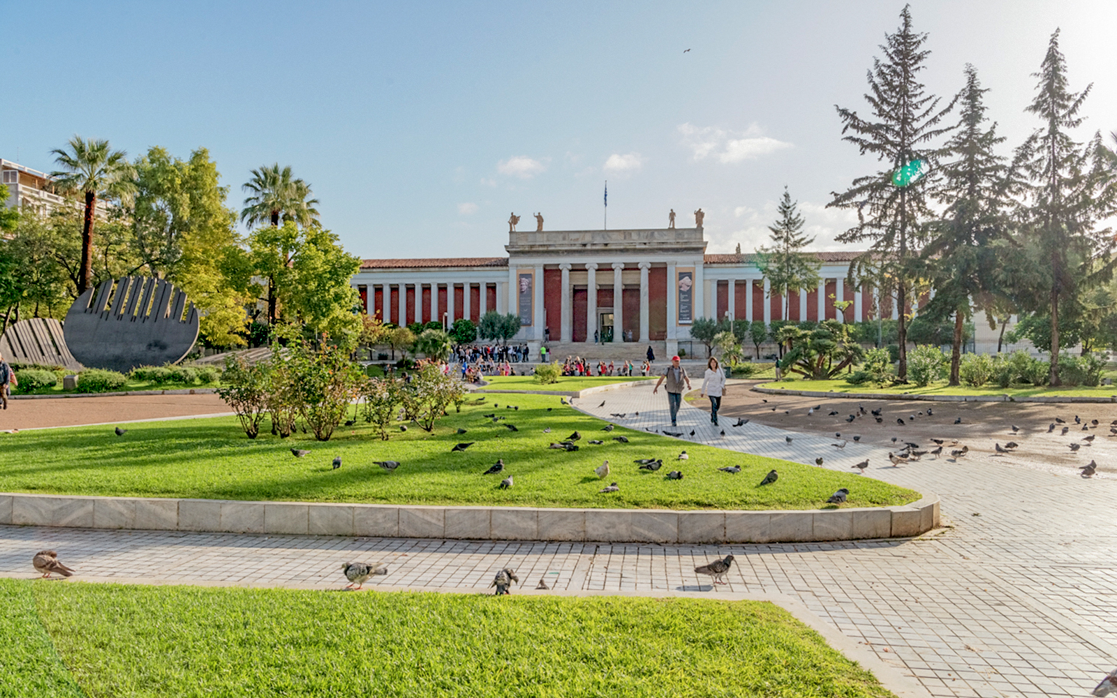 National Archaeological Museum facade with gardens and visitors in Athens.
