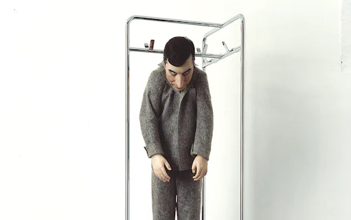 Sculpture of a figure in gray clothing at Palazzo Strozzi's "Reaching for the Stars" exhibition.