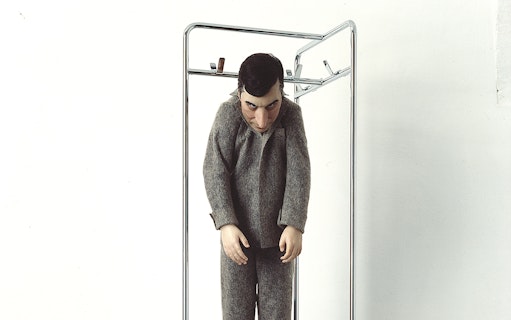Sculpture of a figure in gray clothing at Palazzo Strozzi's "Reaching for the Stars" exhibition.