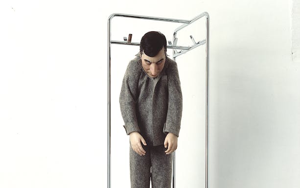 Sculpture of a figure in gray clothing at Palazzo Strozzi's "Reaching for the Stars" exhibition.